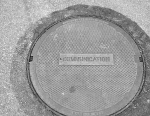 Man hole cover reading "communication"